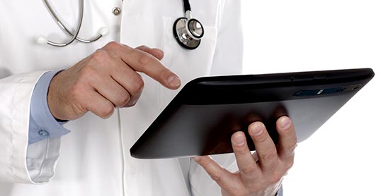 A doctor is using an ipad to check his health.