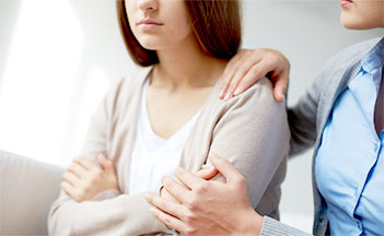 A woman with her arms around another person.