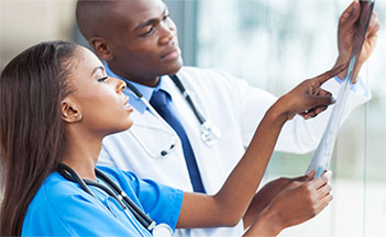 A doctor and nurse looking at something on a tablet.