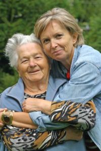 Two women hugging each other in a park.